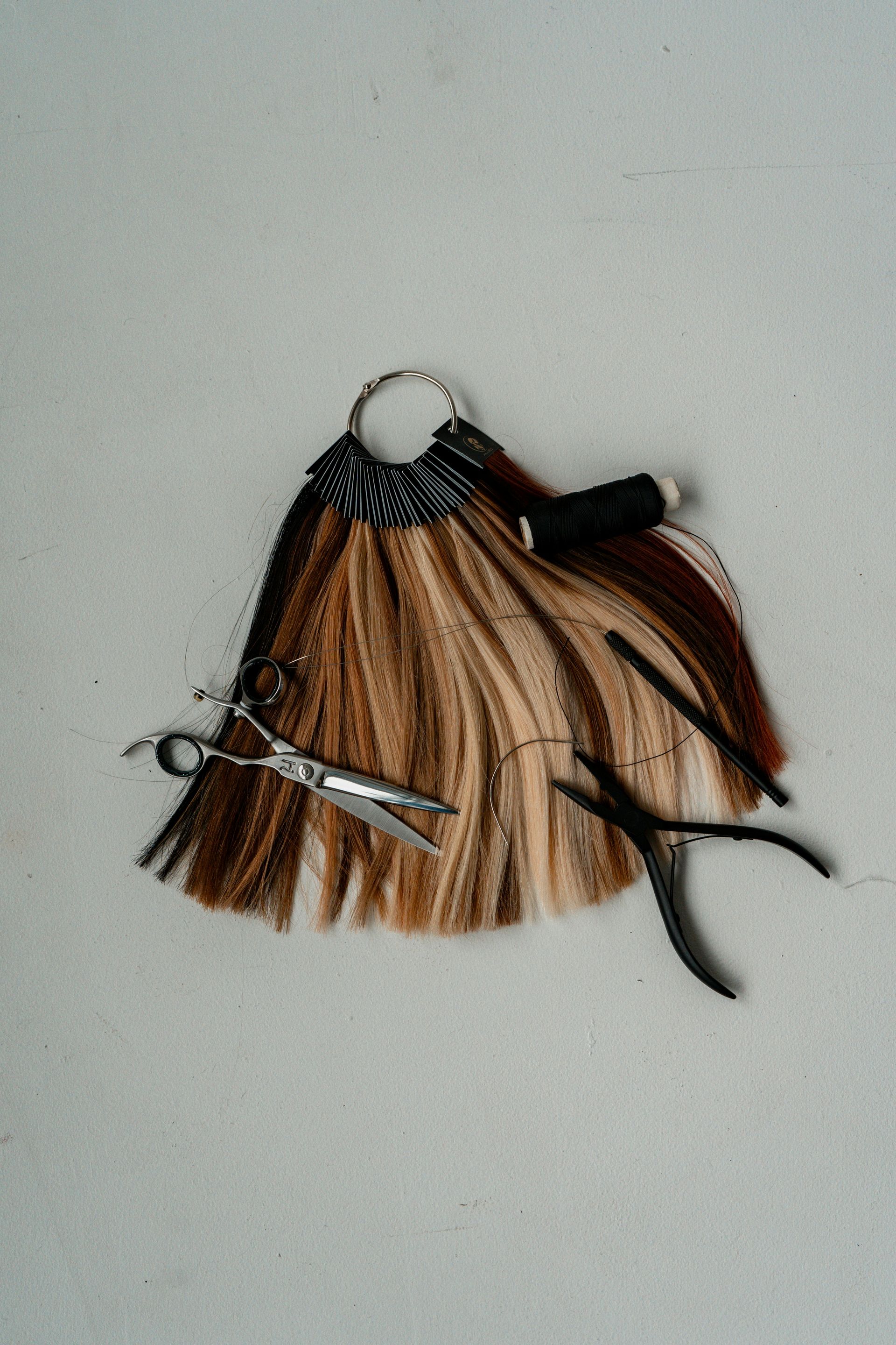 a pair of scissors sitting on top of a piece of hair